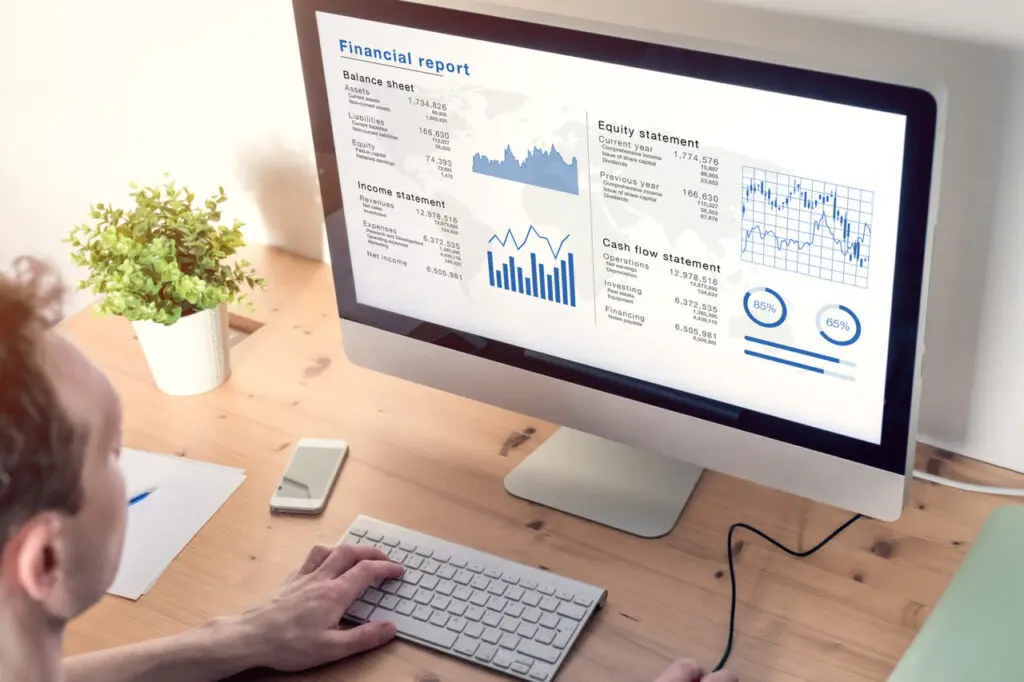 Man ponders and analysing wealth abundance in front of his computer