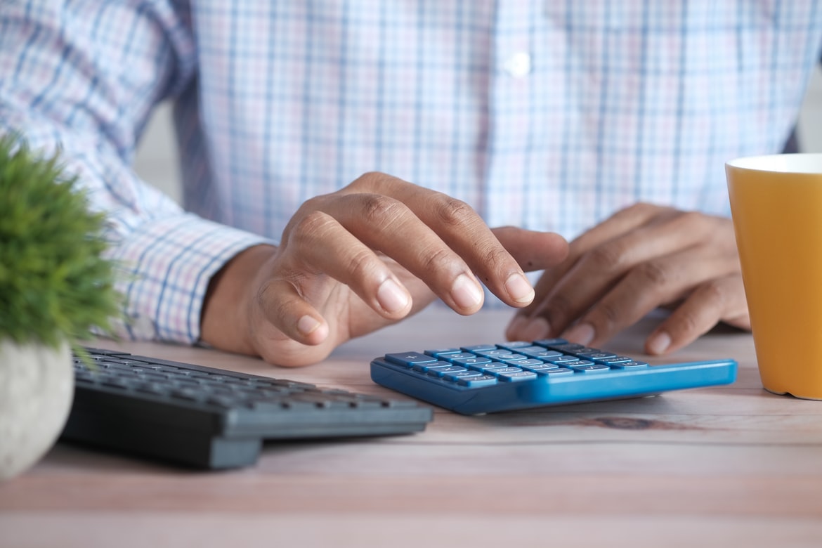 Man using calculator for Income Protection Insurance computation.
