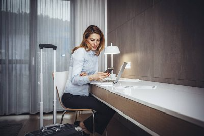 Woman using her phone and has peace of mind with versatile insurance products.