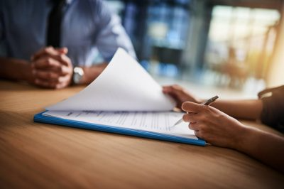 Woman confidently signs insurance product documents for personalized coverage.