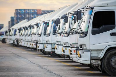 Row of commercial trucks parked on the street for insurance coverage.