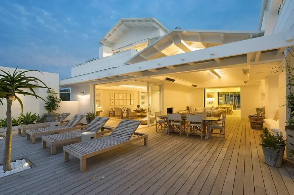 Modern outdoor patio with loungers and dining area.