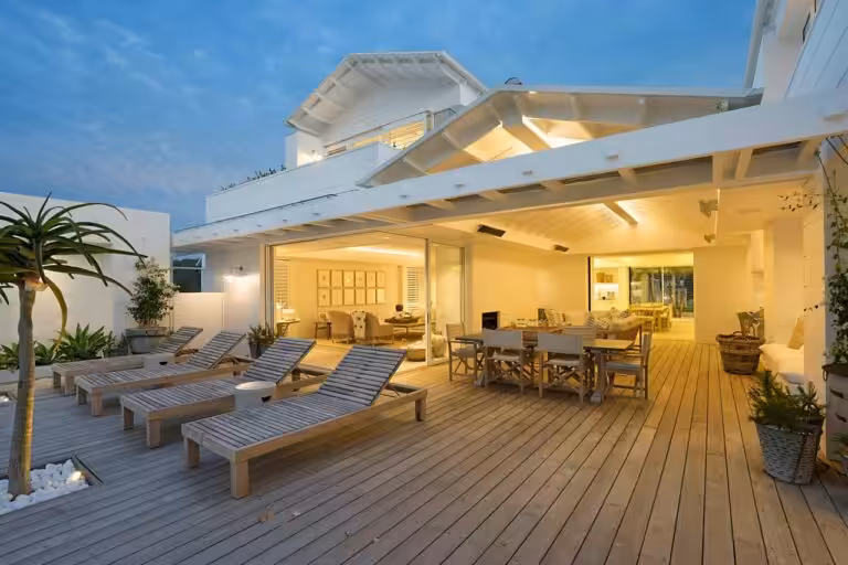 Modern outdoor patio with loungers and dining area.