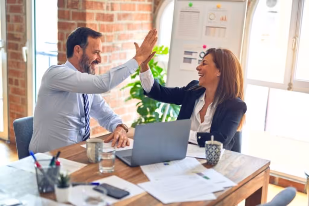 Man high-fiving an insurance agent after financial success