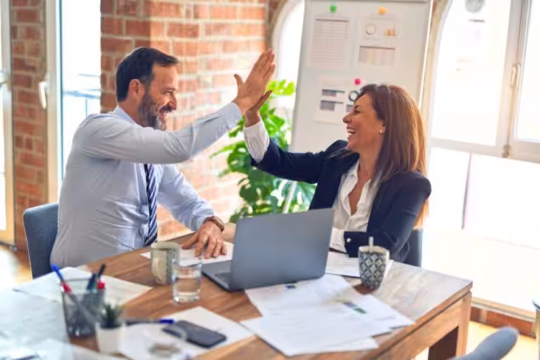 Man high-fiving an insurance agent after financial success