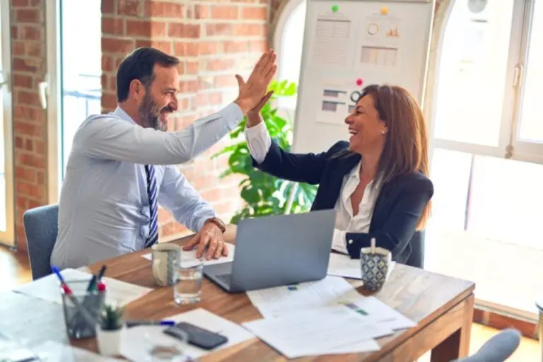 Man high-fiving an insurance agent after financial success