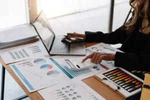 Person analysing financial charts on laptop and calculator.