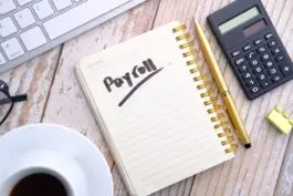 Payroll notebook with calculator and coffee