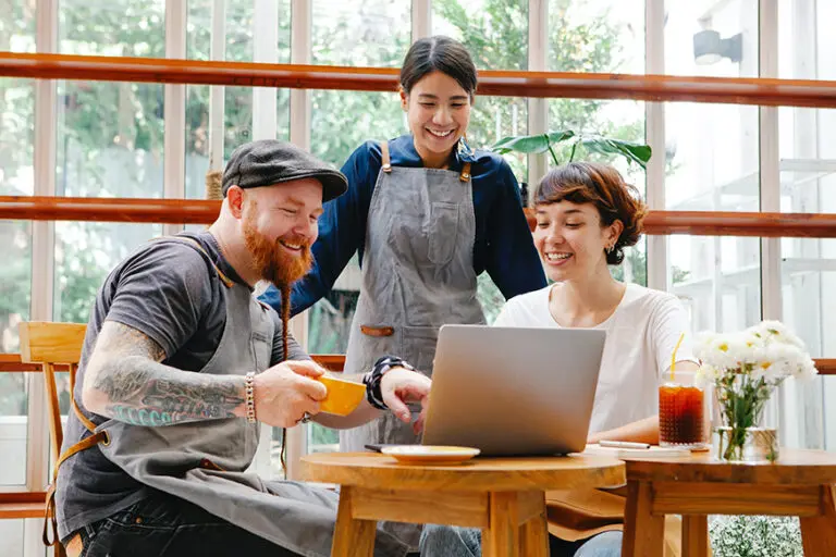 Cafe staff smiling at laptop