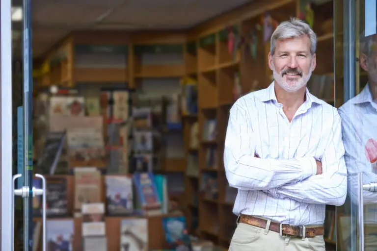 portrait of male bookshop owner outside store