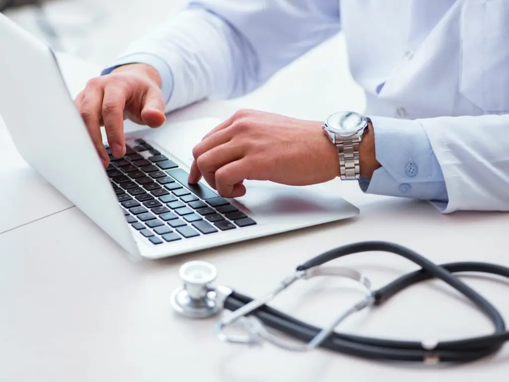 Doctor typing on laptop with stethoscope comparing home loans