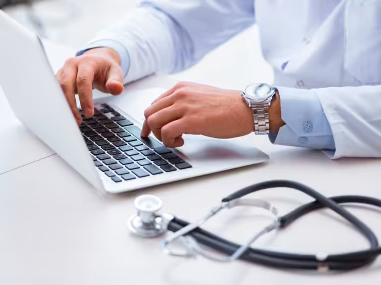 Doctor typing on laptop with stethoscope comparing home loans