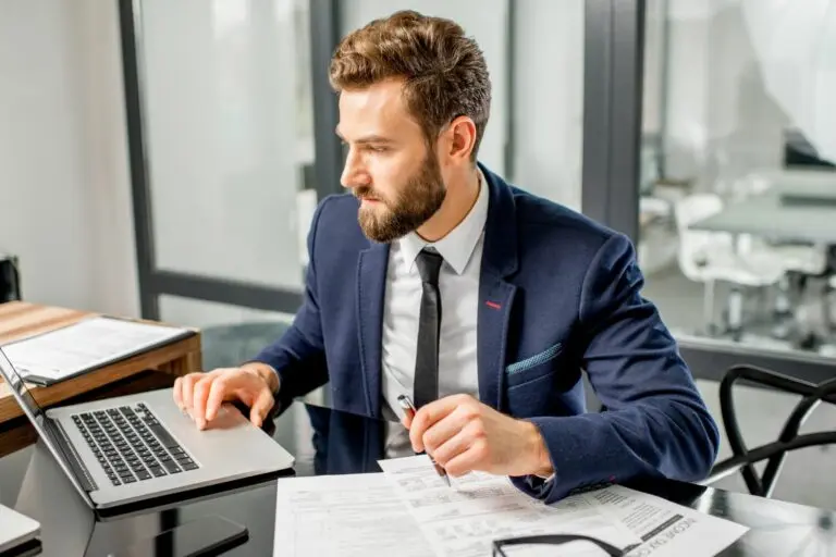 Businessman working on laptop in office.