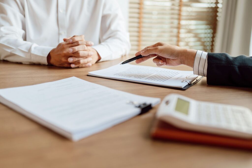 Business meeting with documents and calculator on table