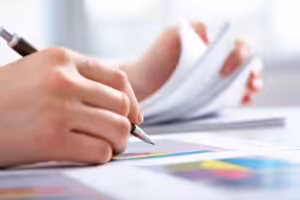 Person reviewing financial documents and graphs with expert financial planning and accounting services.