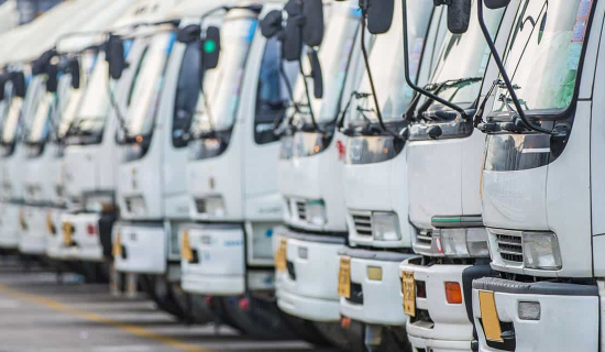 Convoy of white trucks lining the street, exemplifying the robust coverage provided by Commercial Motor Insurance.